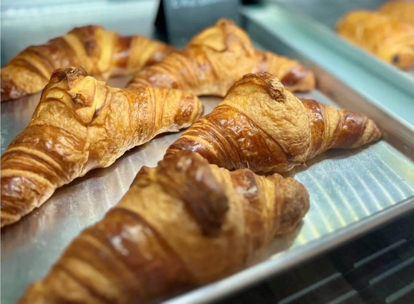 Fresh croissants on a tray at Lily Paris Bakery